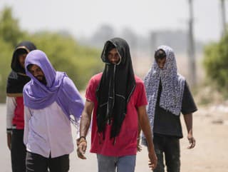 Ľudia si pokrývajú hlavy šatkami ako ochranu pred ostrým slnkom počas horúceho letného dňa v indickom Džammú, utorok 28. mája 2024.