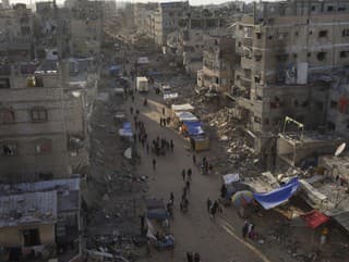 Palestínčania prechádzajú troskami po