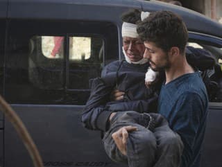 Palestínčan nesie zraneného chlapca