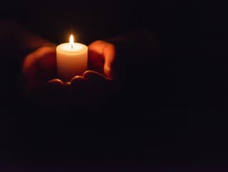 Hands holding burning candle