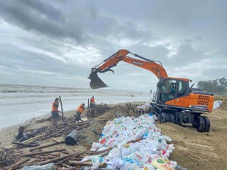 Pracovníci spevňujú hrádzu pred