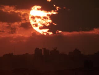 Slnko zapadá za budovami