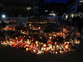 Ľudia zapaľujú sviečky a