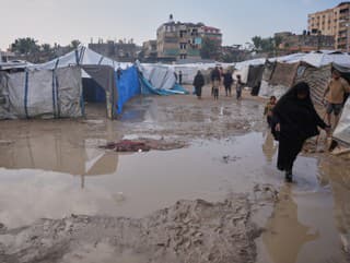 Palestínčania prechádzajú zaplavenou oblasťou