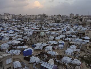 Ľudia prechádzajú cez stany,