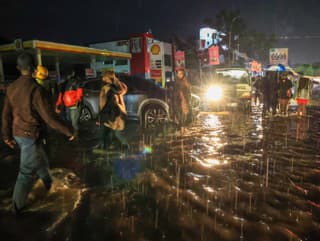 Ľudia prechádzajú cez záplavovú