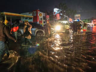 Ľudia prechádzajú cez záplavovú