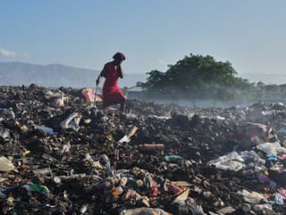 Žena hľadá v odpadkoch