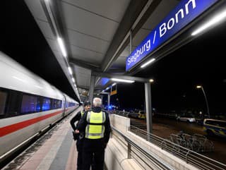 Policajti stoja na nástupišti