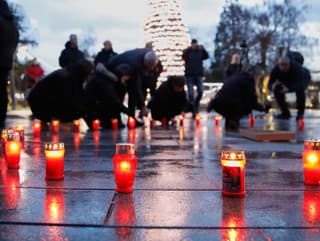 Ľudia zapaľujú sviečky, aby