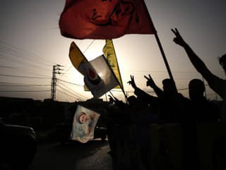 Ľudia mávajú vlajkami Hizballáhu