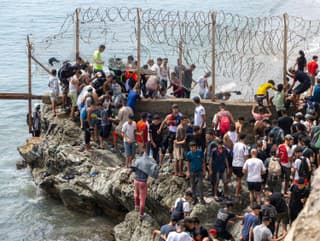 Migranti prechádzajú cez ostnatý