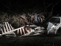Zničené špirálovité schodisko leží v krove pri bielom pickupe na ostrove Sanibel, Florida.