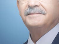 Muž stojí pred portrétom s podobizňou tureckého prezidentského kandidáta Kemala Kiličdarogla