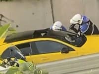 Na zábere z videa dvaja policajti vypočúvajú vodiča, jeden z nich mieri zbraňou na okno žltého auta v Nanterre vo Francúzsku