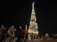 Iračania sa zhromažďujú okolo vianočného stromčeka počas novoročných osláv v Bagdade 31. decembra 2023