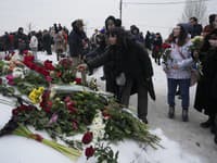 Ľudia kladú kvety, aby si uctili pamiatku zosnulého ruského opozičného lídra Alexeja Navaľného na ulici neďaleko Borisovského cintorína