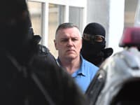 Odsúdený Mikuláš Černák prichádza v sprievode eskorty na verejné zasadnutie