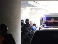 Odsúdený Mikuláš Černák prichádza v sprievode eskorty na verejné zasadnutie