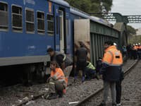 Železniční pracovníci kontrolujú osobný vlak po zrážke s údržbovým vlakom.