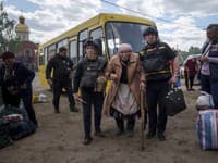 Záchranári pomáhajú 88-ročnej žene po evakuácii z mesta Vovčansk v Charkovskej oblasti na severovýchode Ukrajiny