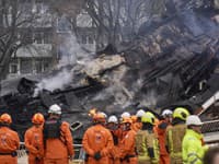 Hasiči stoja pri zničenej budove na mieste výbuchu, ktorý zničil niekoľko bytov a zranil viacero ľudí v Haagu.