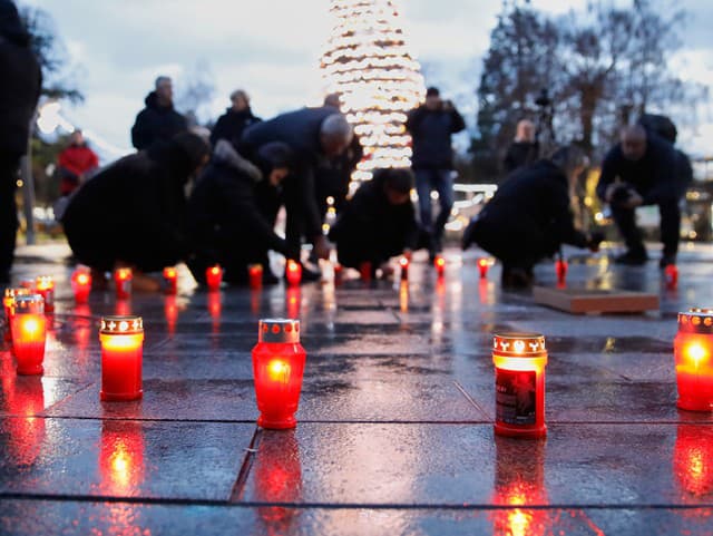 Ľudia zapaľujú sviečky, aby