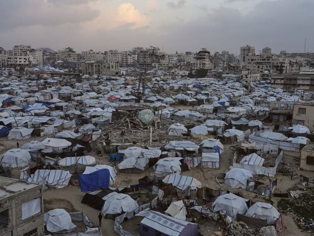 Ľudia prechádzajú cez stany,