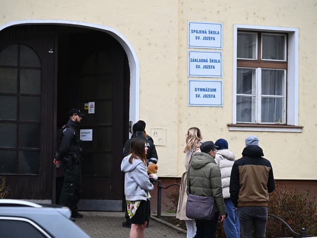 Policajti stoja po streľbe