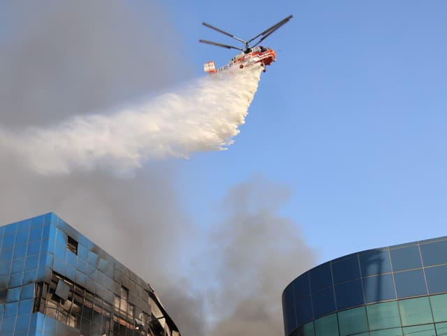 Vrtuľník hasí požiar továrne