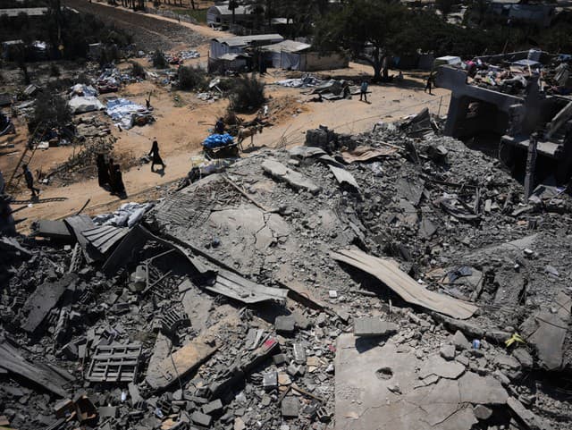 Palestínčania kráčajú okolo zničeného