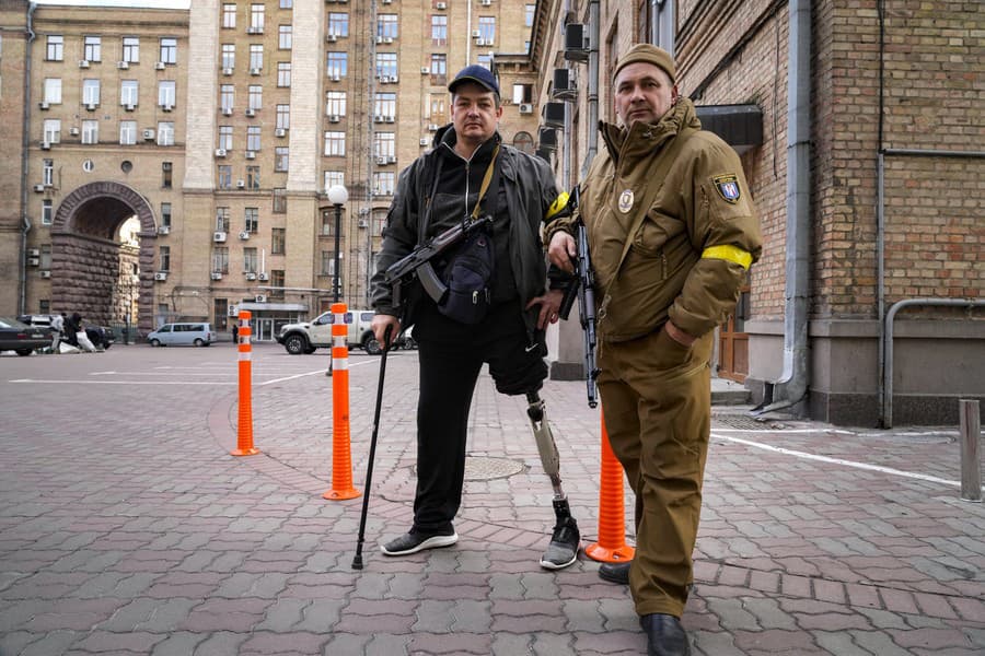 Ozbrojení muži civilnej obrany sa odfotili pri hliadkovaní na prázdnej ulici v dôsledku zákazu vychádzania v Kyjeve na Ukrajine