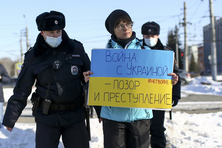 Policajti zatýkajú ženu počas akcie proti ruskému útoku na Ukrajinu, v ruskom Omsku 