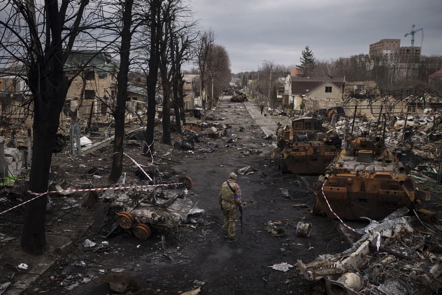 Ukrajinský vojak kráča pomedzi zničené ruské tanky v Buči