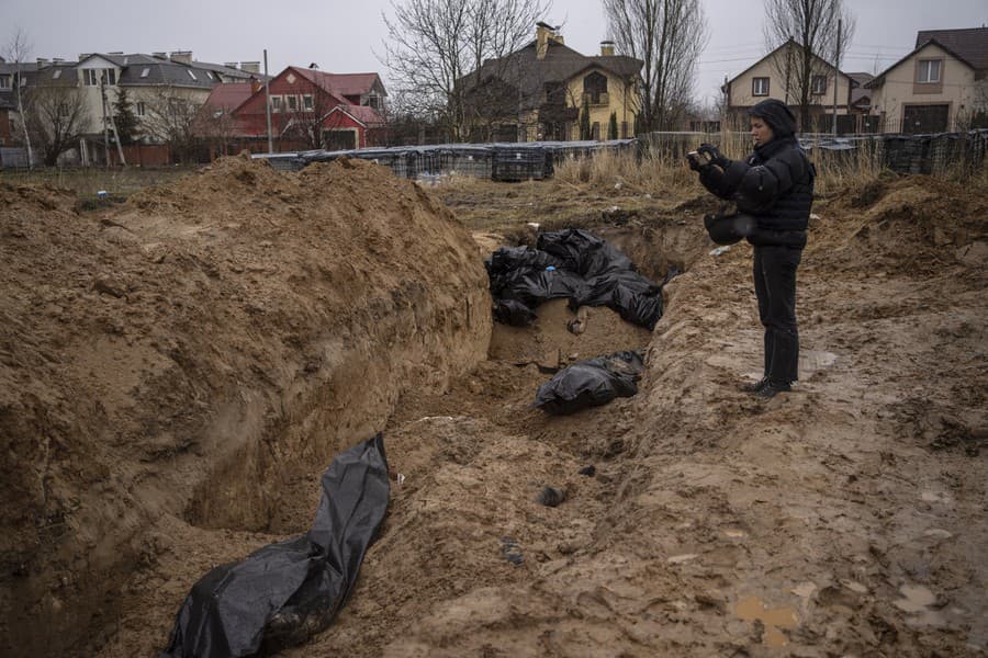 Novinár natáča masový hrob v Buči.
