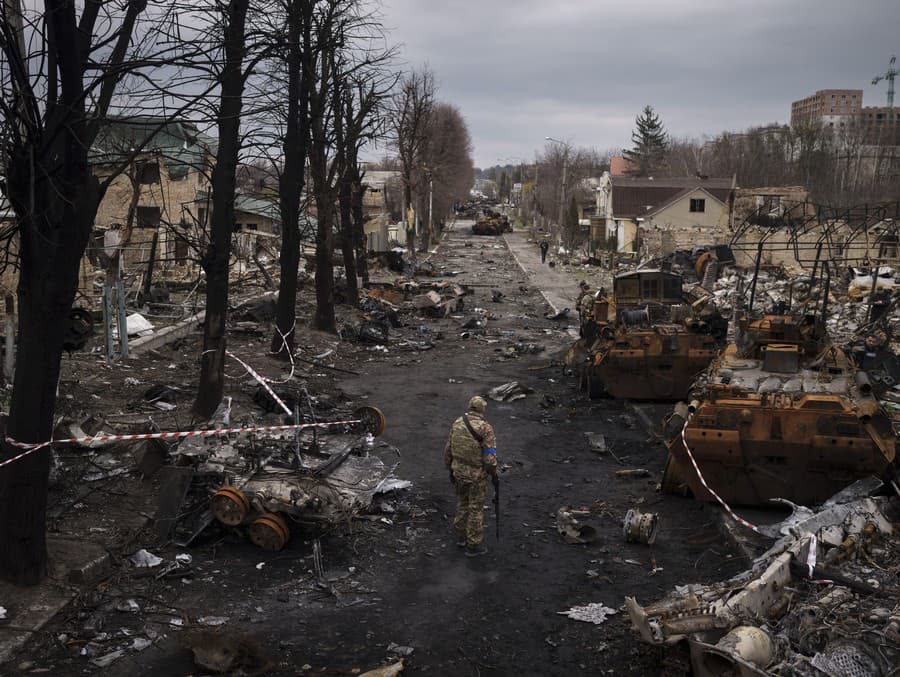 Ukrajinský vojak kráča pomedzi zničené ruské tanky v Buči