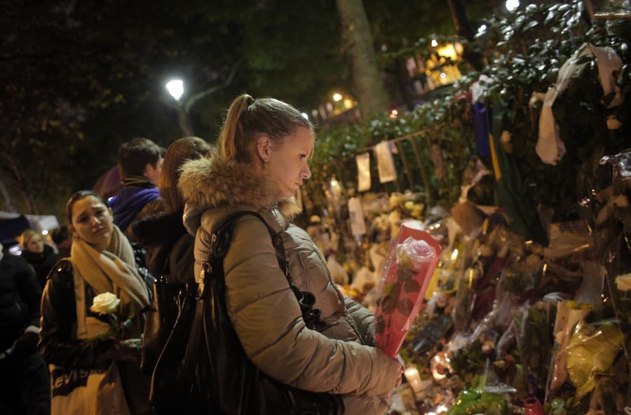Žena vzdáva úctu obetiam pred koncertnou sálou Bataclan, ktorá bola miestom útokov v Paríži, v piatok 17. novembra 2015.
