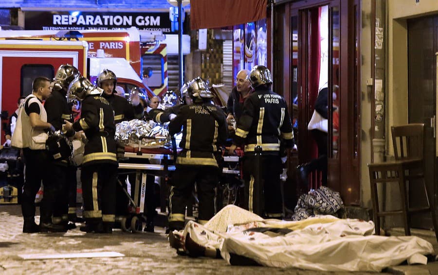 Záchranári sa starajú o obete pred kaviarňou v Paríži, 13. novembra 2015.
