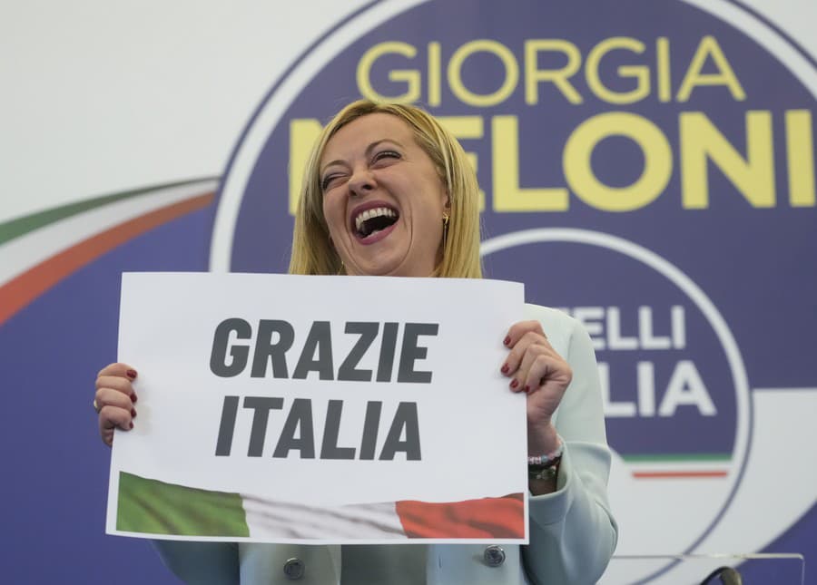 Líderka krajne pravicovej strany Bratia Talianska Giorgia Meloniová ukazuje v nedeľu 25. septembra 2022 vo volebnom sídle svojej strany v Ríme plagát s nápisom v taliančine „Ďakujem, Taliansko“.