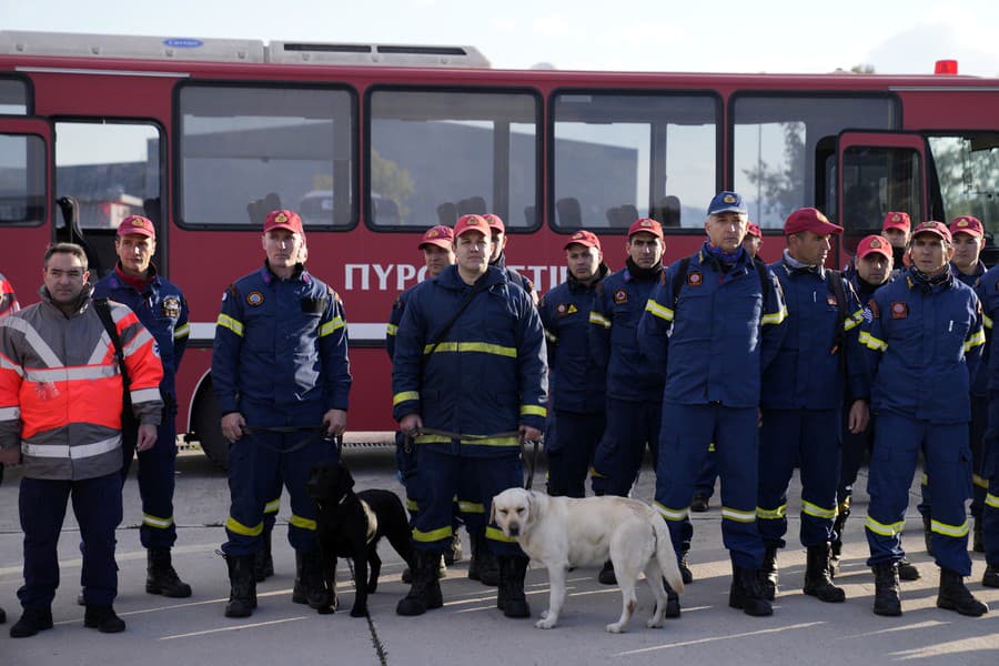 Grécki hasiči so psami čakajú na nástup do vojenského lietadla
