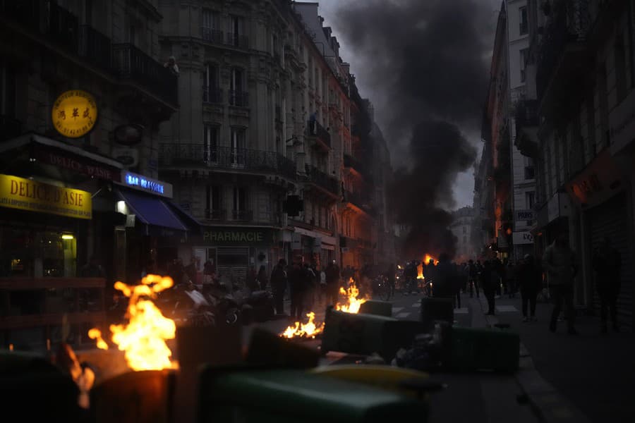  Demonštranti protestujú po televíznom prejave k národu francúzskeho prezidenta Emmanuela Macrona a zapaľujú ohne, v ktorom obhajoval nepopulárnu dôchodkovú reformu v Paríži v pondelok 17. apríla 2023.