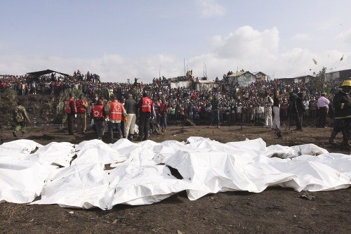 Záchranári stoja blízko mŕtvych tiel obetí výbuchu
