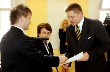 Predseda ÚVK Péter Nyilfa (vľavo) odovzdáva osvedčenie poslancovi NR SR Robertovi Ficovi