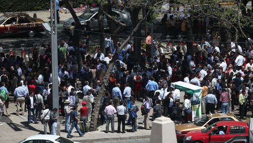 Ľudia na ulici po evakuácii budovy