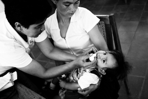 Magna zdravotná sestra očkuje dieťa proti detskej obrne v rámci mobilnej kliniky. NIKARAGUA.