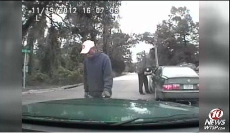 Muž močí na policajné auto