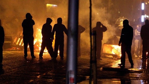 Stovky demonštrantov zablokovali v piatok večer cesty a podpálili autobus