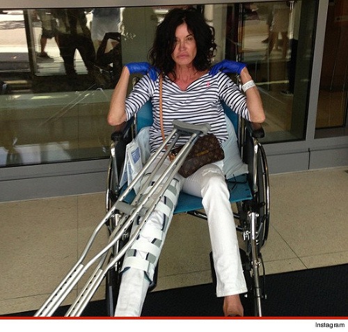 Zúbožená Janice Dickinson sedí na invalidnom vozíku po tom, čo sa dokaličila vlastnou nepozornosťou.