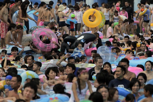 Davy ľudí v bazéne v zábavnom parku v Tokiu sa usilujú ochladiť počas rekordných horúčav