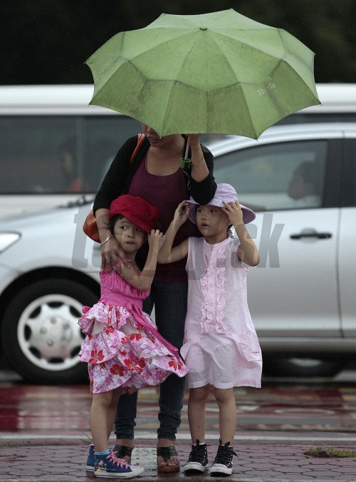 Matka chráni deti pred silným dažďom